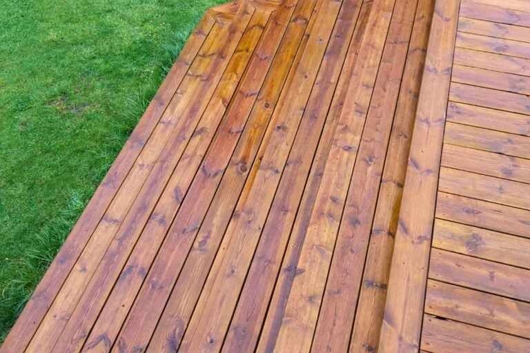 Renset træterrasse med trapper ned til græsplænen