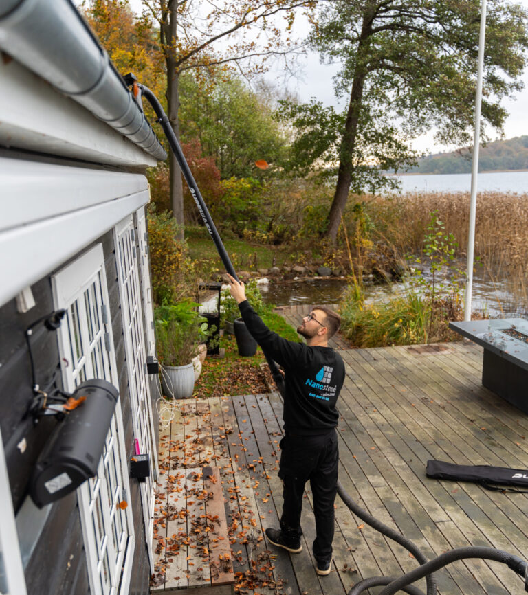 Professionel rensning af tagrender på sommerhus udført fra jorden med teleskopudstyr