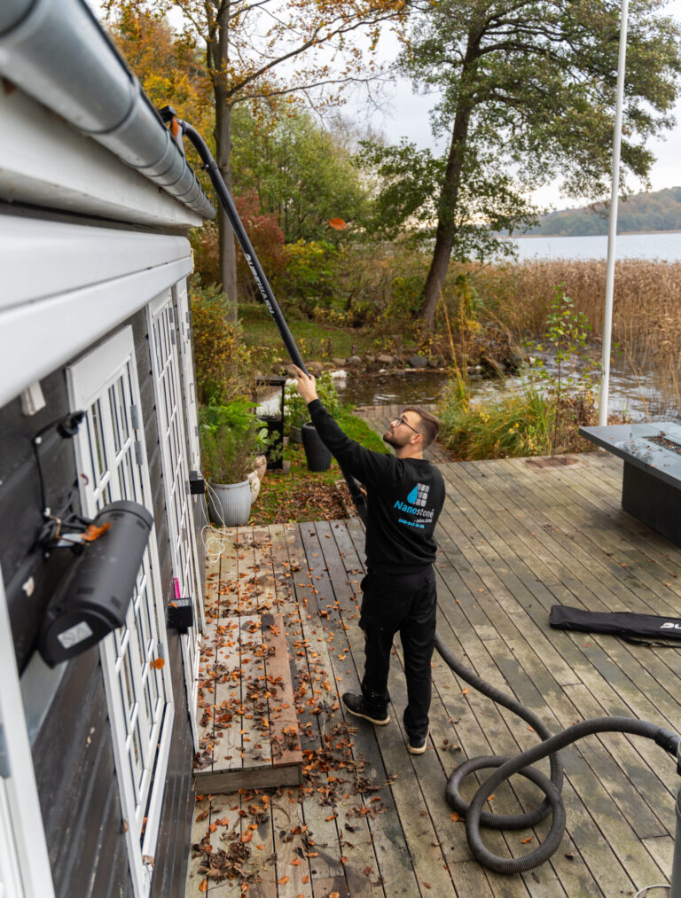 Professionel rensning af tagrender på sommerhus udført fra jorden med teleskopudstyr