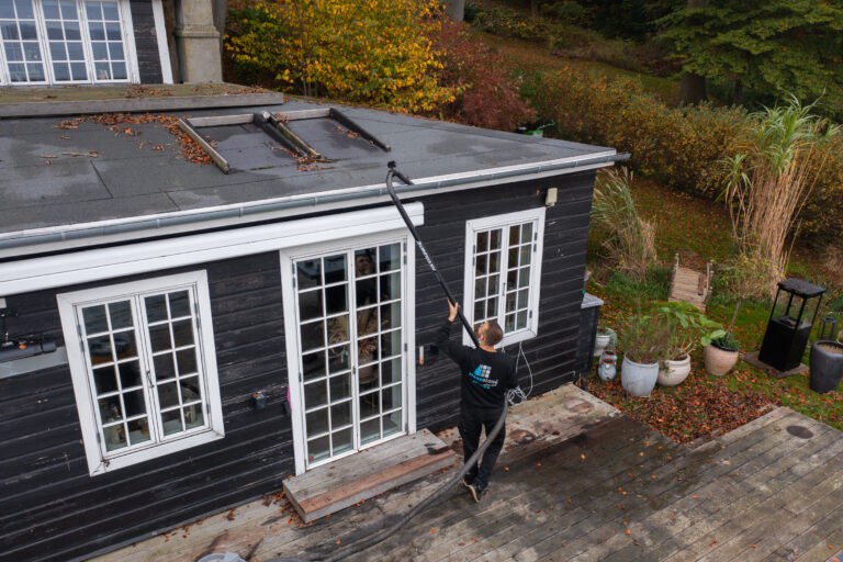 Professionel rensning af tagrender på villa i Danmark udført med specialudstyr fra jorden