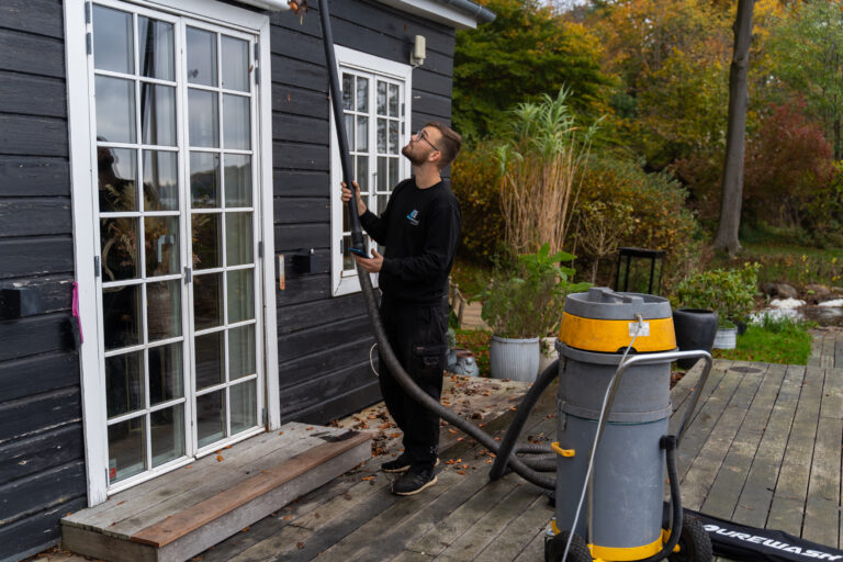 Professionel rensning af tagrender på villa udført fra jorden med specialudstyr