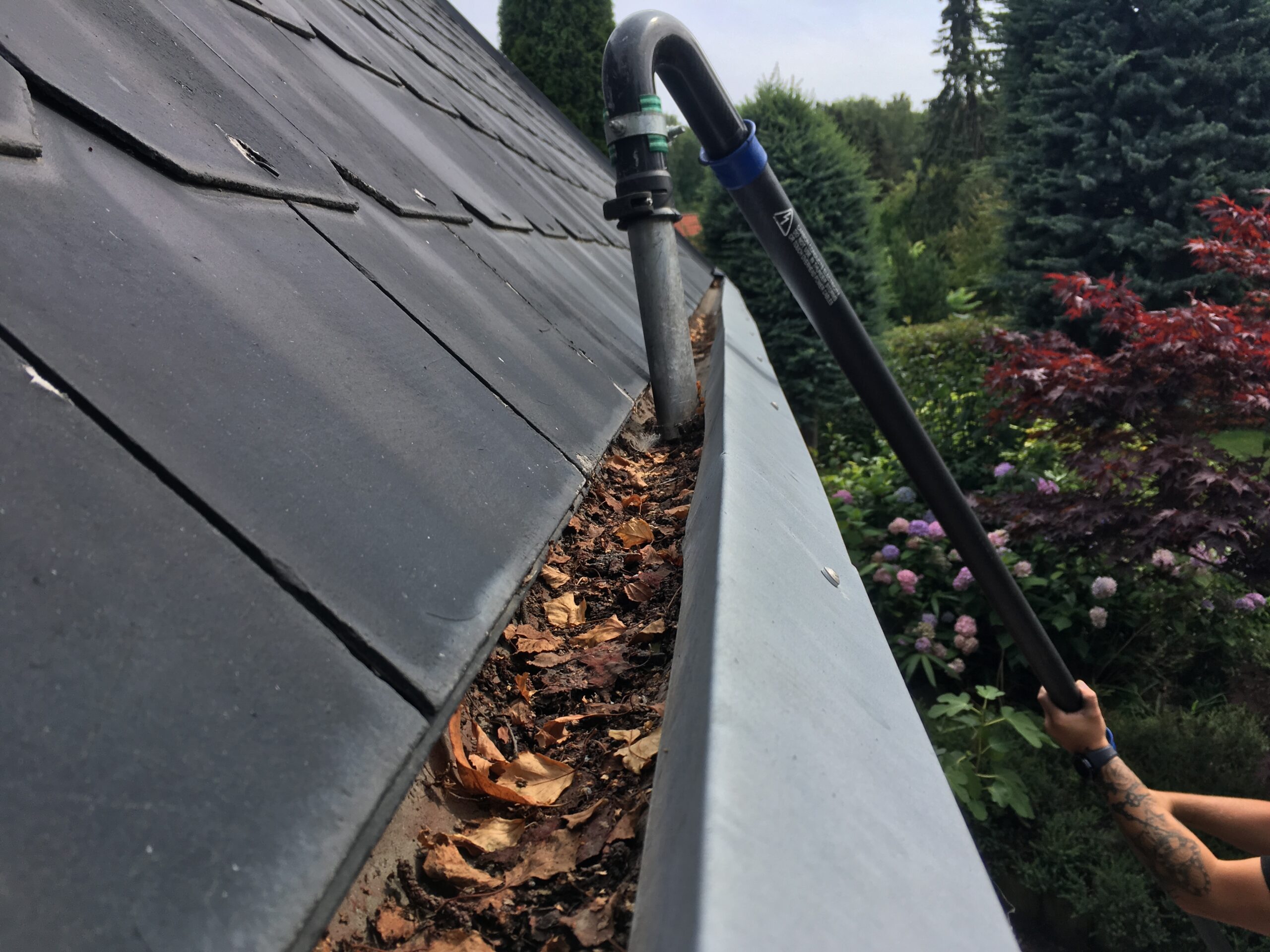 Tilstoppet tagrende med blade og snavs renses effektivt med professionelt udstyr