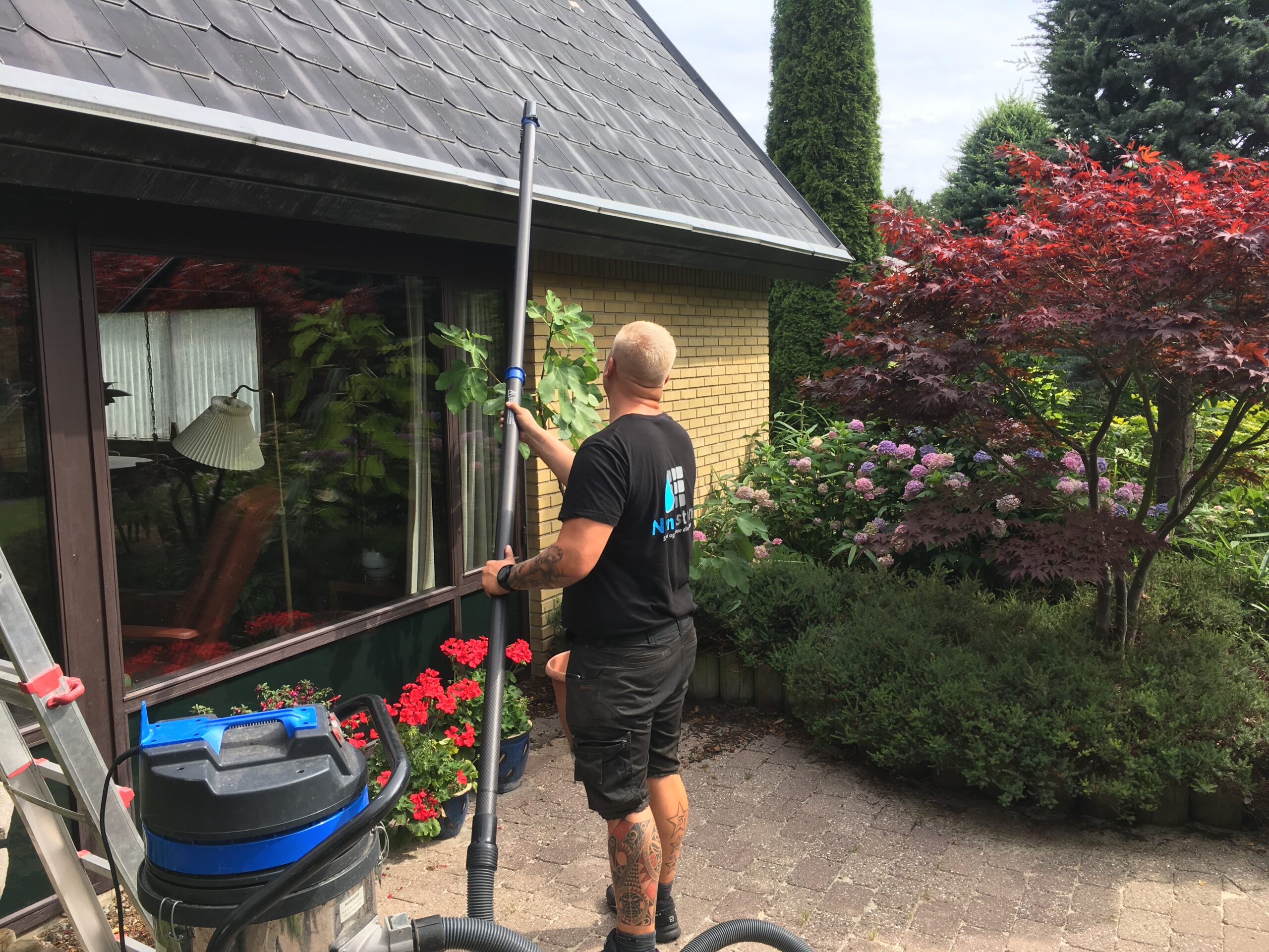 Professionel rensning af tagrender fra jorden på villa udført af Nanostone med specialudstyr.