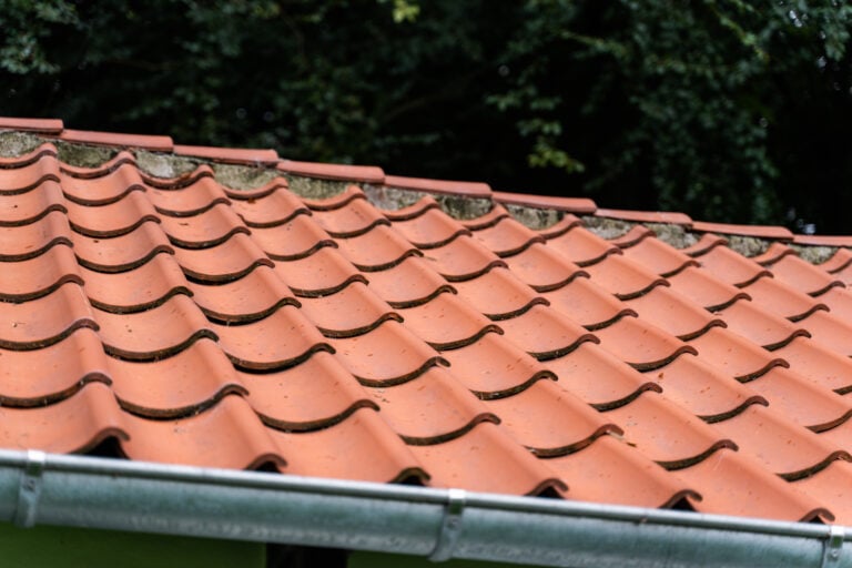 algebehandling af tag af et betongtegl tag som er ramt af en smule algevækster og mos.