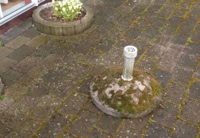 Beskidte fliser, bed og parasolfod med algebelægninger, mos og flisepest.