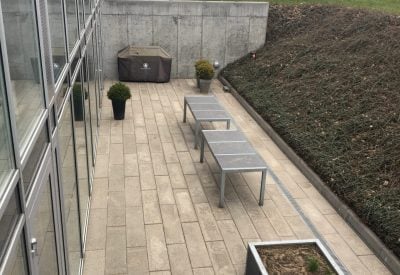 Renset fliseareal ved glasfacade og siddeområde i Helsingør efter fliserens