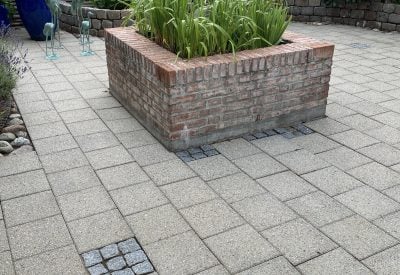 Ren flisebelægning omkring muret plantekasse i Taastrup efter fliserens