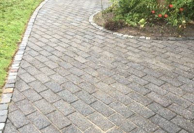 Ren belægning langs buet havebed i Haslev efter fliserens